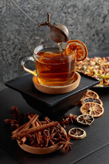 Cup of herbal tea with ingredients and slices of dried orange slices.