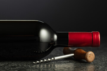 Corkscrew and bottle of red wine.