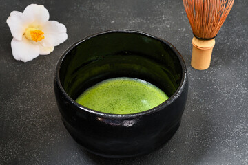 日本の茶道　茶碗と抹茶と美しい椿 　黒背景　コピースペースあり　Japanese Tea Ceremony (Chado) : Tea bowl, matcha (green tea) and beautiful camellia on black background, copy space available
