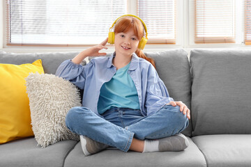 Cute redhead girl listening to music at home