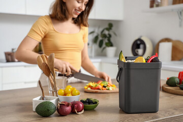 Young woman with compost bin during cooking in kitchen
