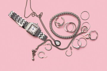 Beautiful silver jewelry and wrist watch on pink background