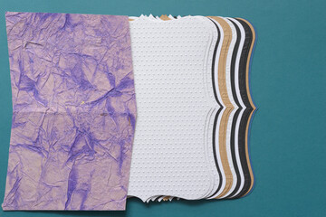 rag-textured crafting paper and a set of staggered insert cards with elegant scalloped edges on blue
