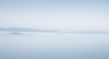 Fototapeta premium A serene and minimalist view of a mountain range barely visible through a thick layer of pale, wispy clouds