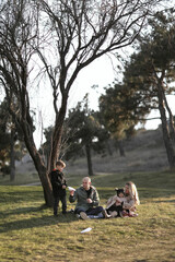 Fototapeta premium Happy family playing with paper planes in a blooming spring park with a city view