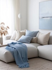 A cozy sofa is displaying cushions and a blue throw
