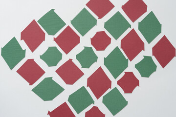 irregularly cut red and green paper tiles on blank paper