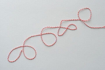 length of red and white twisted thread on blank paper