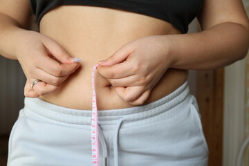 woman measuring her waist