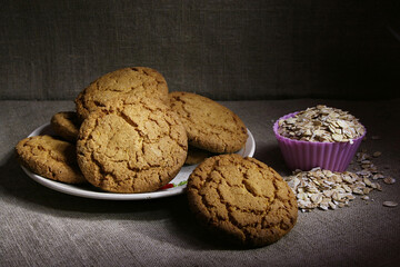 Oatmeal cookies and a silicone baking mold full of oatmeal on a gray linen fabric