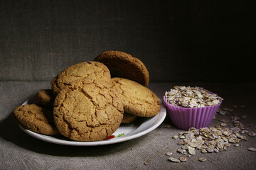 Oatmeal cookies and a silicone baking mold full of oatmeal on a gray linen fabric