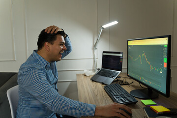 Excited stock trader celebrating a successful deal, feeling euphoric while working from a home...