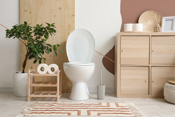 Interior of restroom with toilet bowl, stand and commode