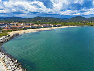 Fototapeta premium Beach with waves in Port Grimaud looking towards Saint Maxime in France in spring, drone photo