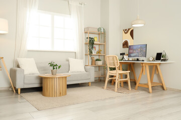 Computer with launched video game on table in stylish living room