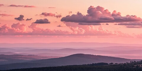 Obraz premium a breathtaking panoramic view of a mountain landscape at sunset. The sky is filled with soft, colorful clouds and layers of rolling hills