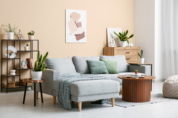 Interior of living room with sofa, tables and green plants