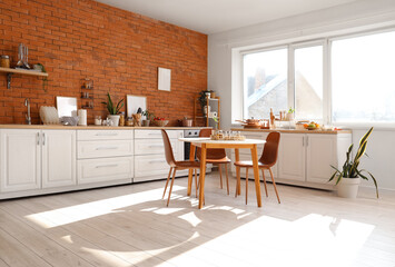Interior of kitchen with counters, dining table and utensils