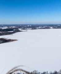 Obraz premium Winter landscape with country road near Sivers lake. Latvia, Latgale.