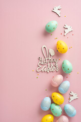 Colorful vertical Easter eggs and festive decorations arranged creatively on a pink background to convey a cheerful holiday feeling