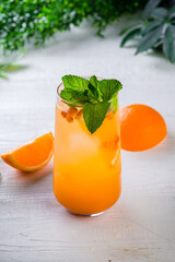 orange lemonade on a white table, vertically