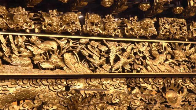 The temple's support beams are filled with finely detailed, gold-plated carvings.