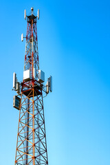 Cellular communication tower against a clear blue sky, modern telecommunications infrastructure