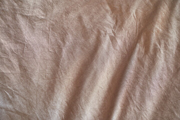 Vintage brown textured fabric with natural folds and wrinkles for rustic decoration.