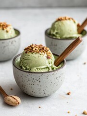 A creamy green ice cream topped with crunchy bits, served in textured bowls with wooden spoons, creating a delightful dessert presentation.