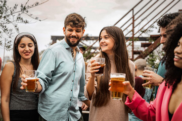 Young friends enjoying beer and socializing at an outdoor gathering