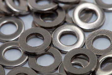 Heap of stainless shims. PIle of shiny screw washers.. Background. Set of metal washers in the foreground