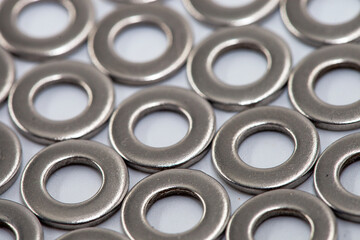Set of metal washers in the foreground. Heap of stainless shims. Background. PIle of shiny screw washers. PIle of shiny screw washers.