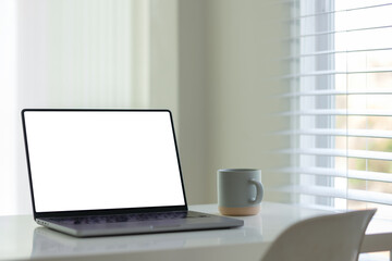 Minimalist home office with laptop and coffee cup.