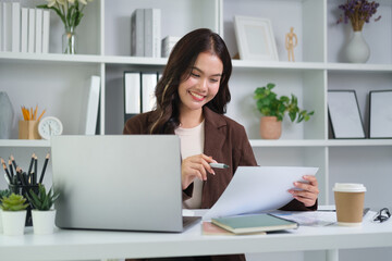 Smiling young female administrative assistant making notes of working planning organizing information in her office.