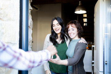Happy LGTBI couple receiving house keys to their new home. Lifestyle.