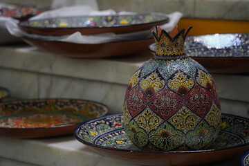 A pomegranate-shaped decanter with a pattern in the Uzbek national style. Craft fair.