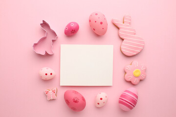 Easter composition. Easter eggs, flowers, paper blank on pastel background. Flat lay, top view, copy space.