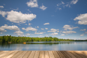 A long-exposure shot of a calm lake with a wooden dock in the foreground in Algonquin Provincial...