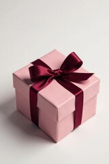 Obraz premium Gift box with burgundy ribbon on a white background, gift wrapping, packaged gift, decorative box
