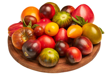 Multicolored tomatoes: red, yellow, orange, green on round wooden board on transparent background. Close-up view from the side