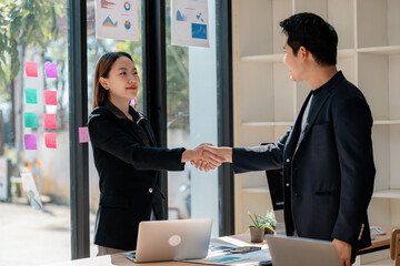 Asian businesspeople shaking hands during a meeting in the office