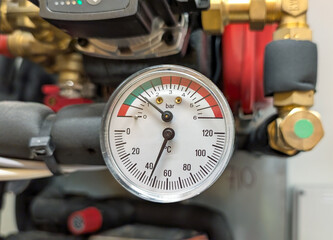 Pressure and temperature gauge on a mechanical or heating system.