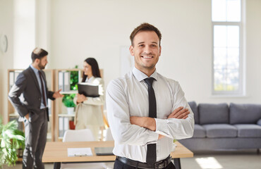 Fototapeta premium Portrait of a happy and successful businessman, manager or accountant smiling in the office while working. Business success, professional management, and a positive work environment.