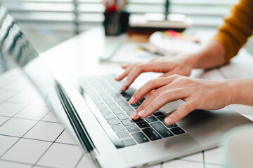Fototapeta premium Typing on keyboard Working online on laptop computer On a white table at the office. Facebook chat. Web meeting. Blogger. Journalist writing an article. online job ideas
