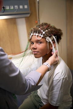 Young patient sits calmly while wearing an EEG cap