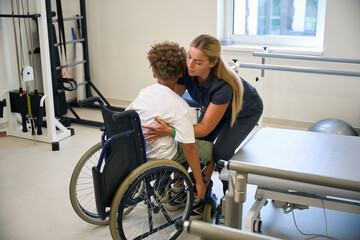 Therapist guides a patient through a safe transfer from wheelchair