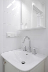 Faucet with ceramic sink and mirror in the bathroom