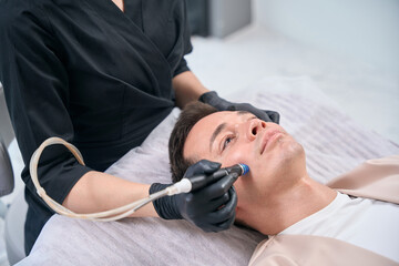 State licensed beautician cleansing and nourishing male client skin