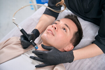 Client of aesthetic cosmetology clinic attending hydrafacial procedure