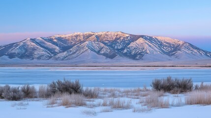 Majestic snow covered mountains and frozen lake under clear skies